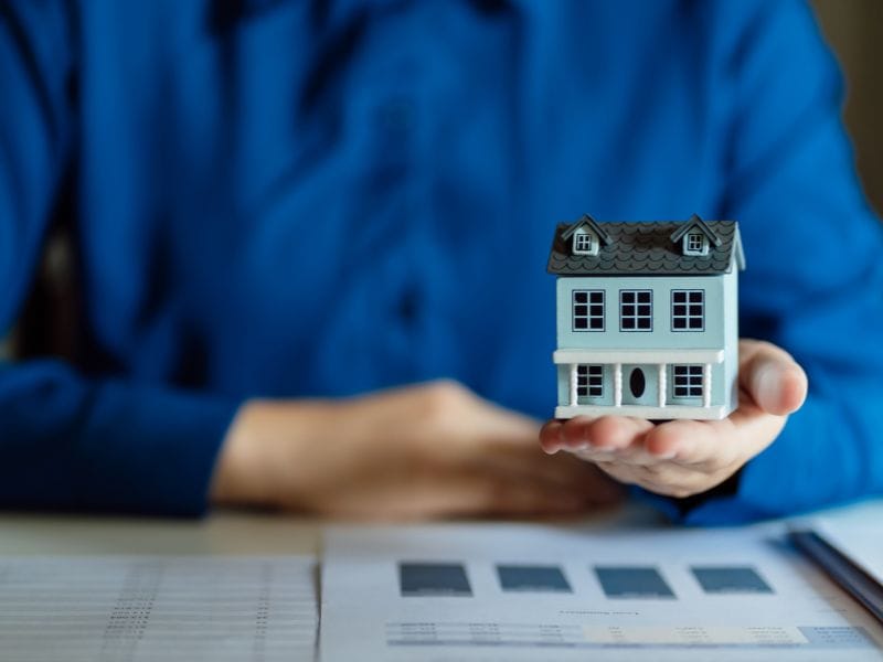 uomo con in mano il modellino di una casa