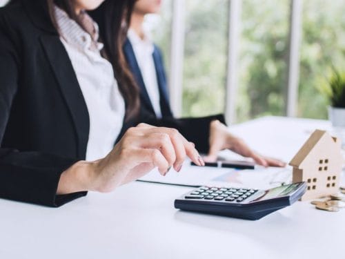 donna con calcolatrice calcola come investire 20.000 euro in immobili