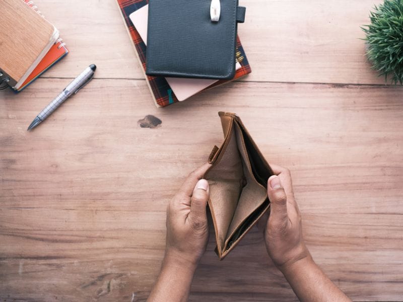 uomo apre portafoglio vuoto a simbolo di investire in immobili senza soldi