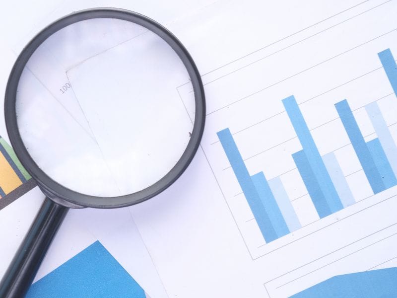 lente di ingrandimento sopra e dei grafici a simboli degli investimenti immobiliari svantaggi da conoscere, trovare e considerare