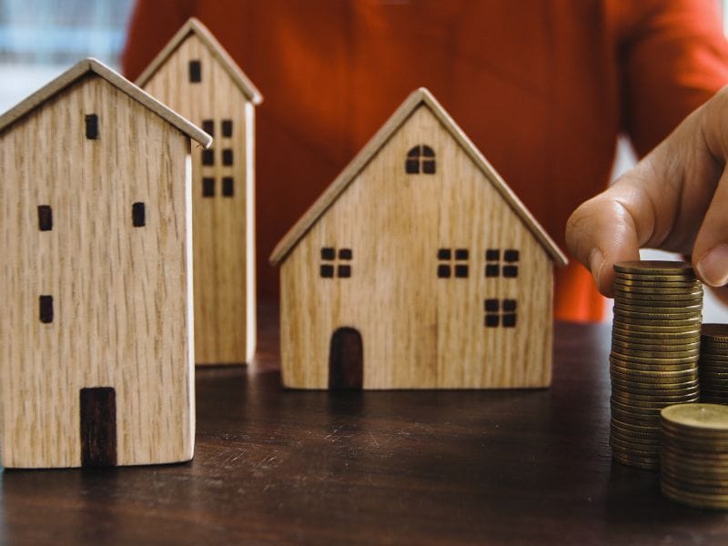 uomo con modellini di proprietà immobiliari in legno